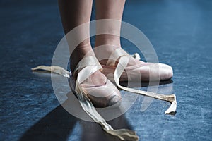 cropped view of ballet dancer in pointe shoes in dark